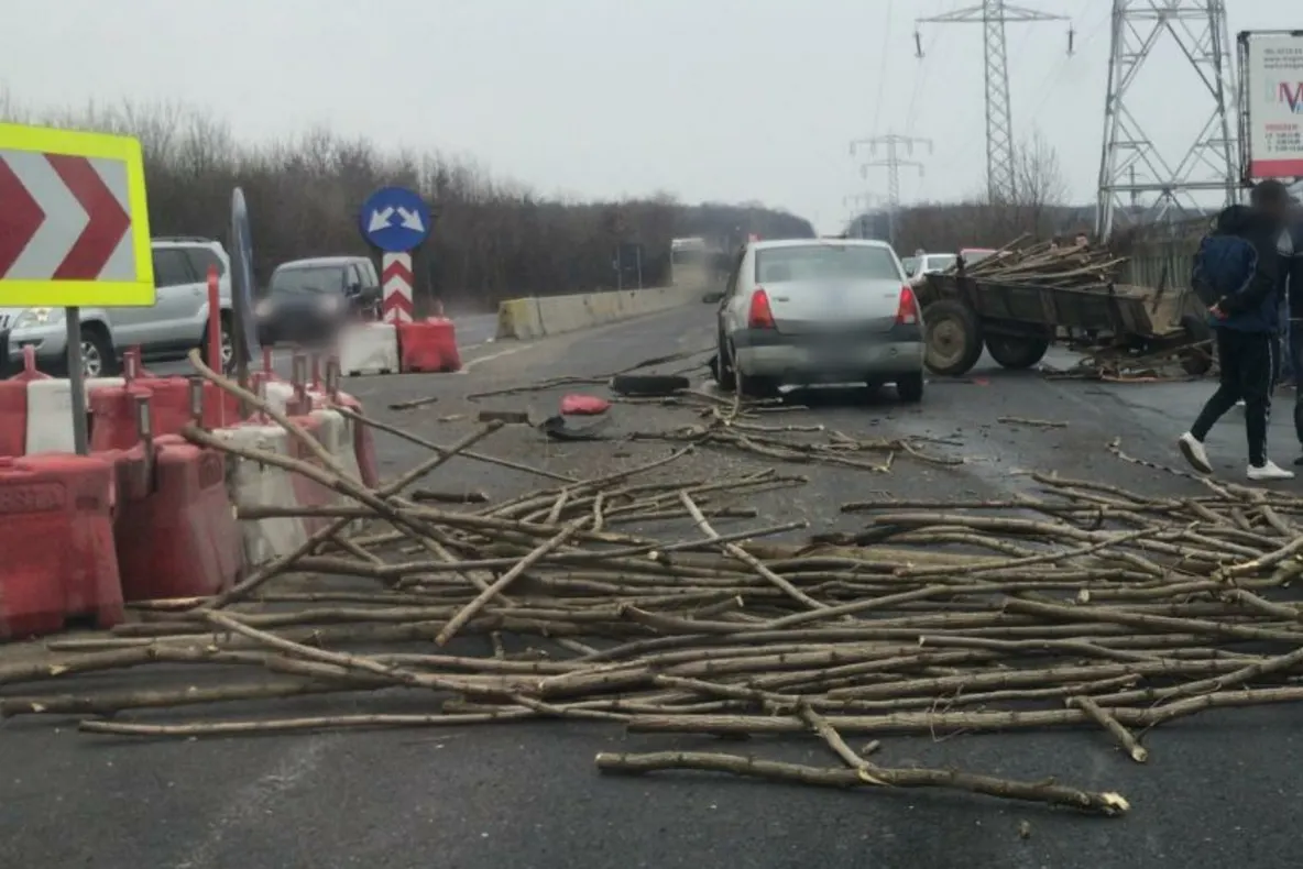 Lemne împrăștiate pe șosea, după ciocnirea dintre o mașină și o căruță